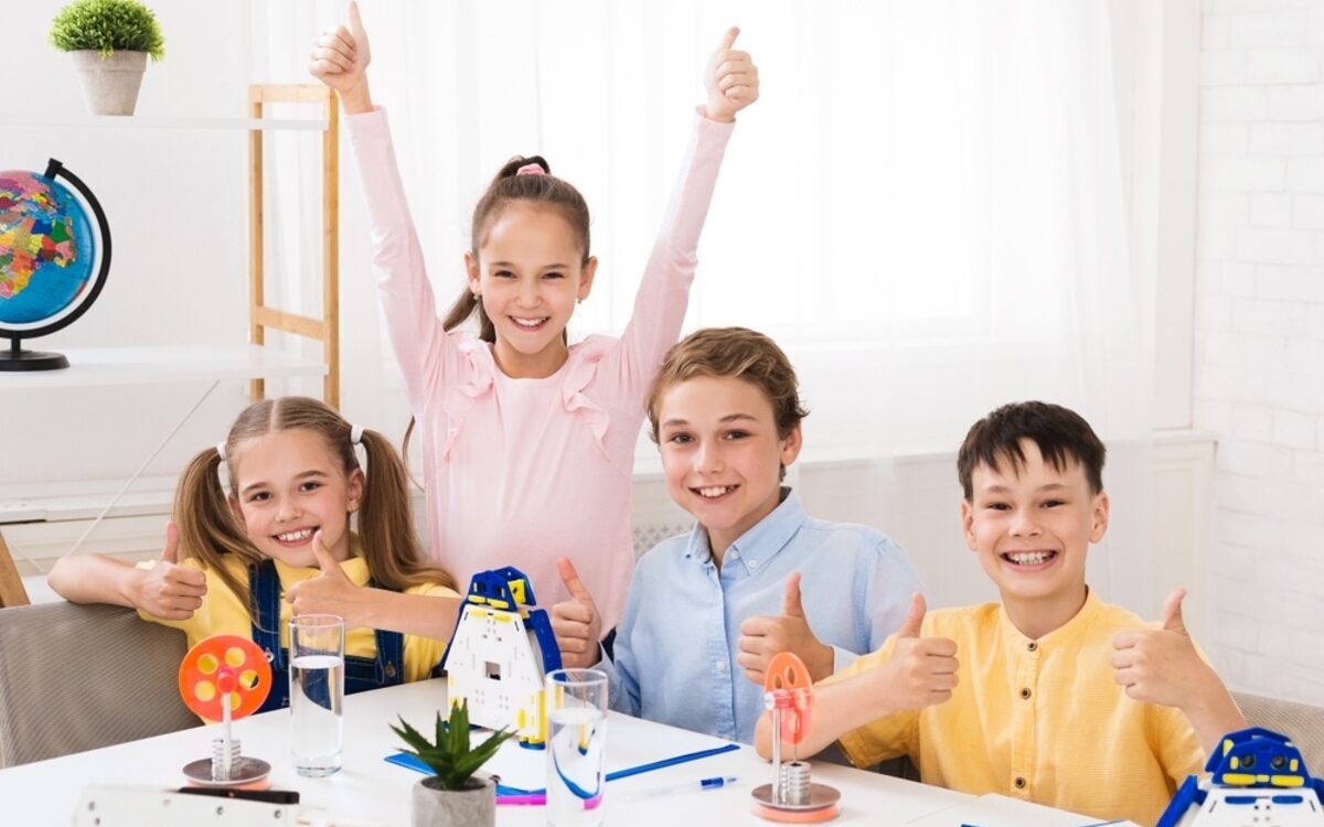 Happy children engaged in a STEM project showing why STEM skills vs academic grades both matter for future success