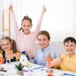 Happy children engaged in a STEM project showing why STEM skills vs academic grades both matter for future success