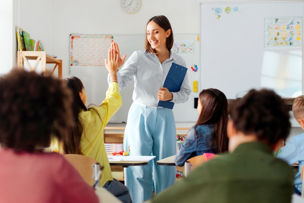Teacher giving a high five to a student in a private school in Brooklyn NY