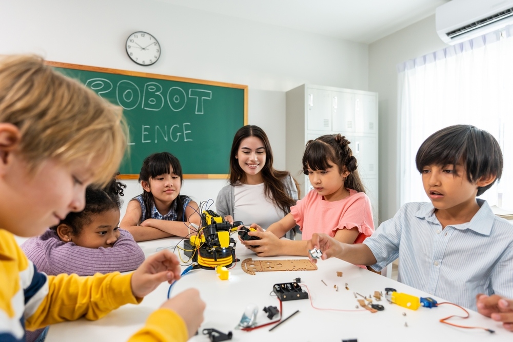 Elementary students and teacher collaborating on a robotics project representing hands-on STEM projects for elementary students in action