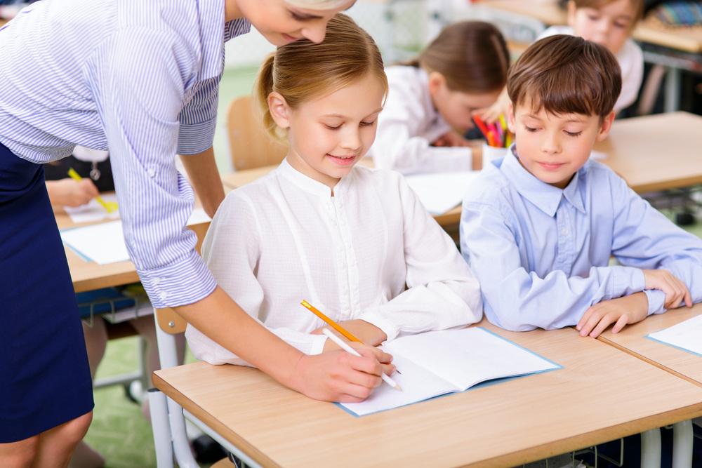 Teacher helping a student with writing at a private school near Sheepshead Bay Brooklyn NY