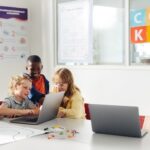 Children collaborating on coding for kids while a classmate explains her idea