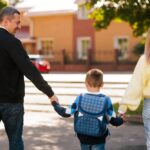 Two parents walking their child to school representing the active private school parent involvement that strengthens the home and school partnership