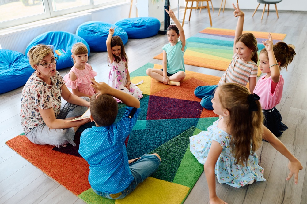 Teacher facilitating an engaged small group discussion with young students illustrating how private school social development happens through daily structured peer interaction