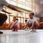 Young students focused and ready to move in a gym class illustrating how STEM and physical education work together to prepare the brain for learning and cognitive performance